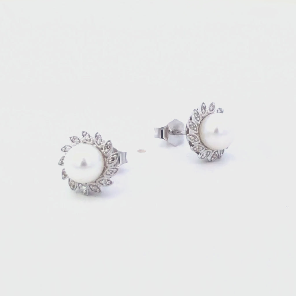 Video of pearl earrings with diamond accents on a white background