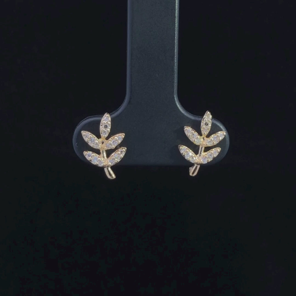 Video of gold leaf-shaped earrings with diamond-like stones on a black background
